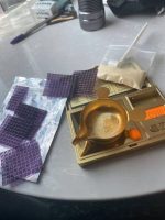 Full sheet of purple pyramid buy LSD gel tabs infused with sparkling gold flakes laid out on a clean surface